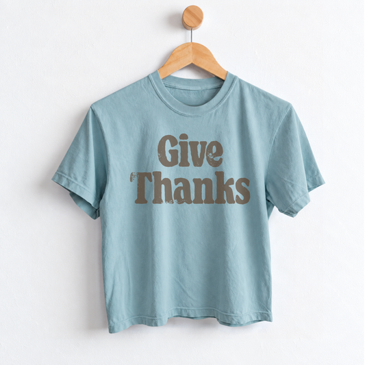 Women’s Give Thanks Thanksgiving graphic tee with garment dyed cotton fabric, mid length silhouette, relaxed fit, crew neckline, and festive fall holiday design.