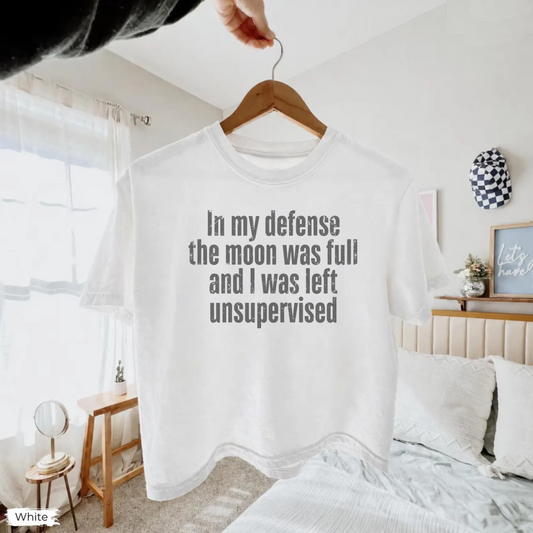 Women’s In My Defense The Moon Was Full and I Was Left Unsupervised graphic tee featuring a funny astrology saying for moon lovers and celestial humor fans. Fineish