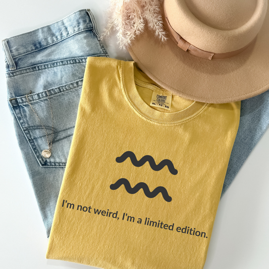 Aquarius zodiac graphic t-shirt featuring the quote "I'm not weird, I'm a limited edition." Astrology inspired unisex tee for Aquarius birthdays, horoscope lovers, and unique personality types.