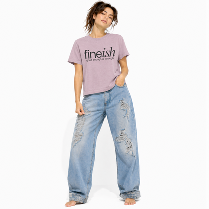Model wearing a vintage lilac FINEish women's relaxed fit t-shirt with the "Good Enough Is Enough" design.