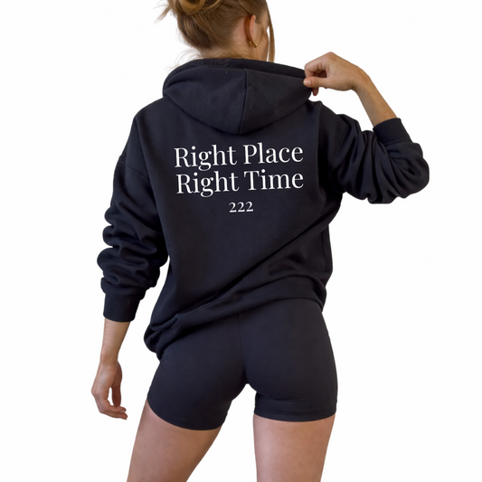 Unisex angel number 222 black hoodie featuring minimal front numerology design and back print reading right place right time, spiritual alignment sweatshirt for divine timing, balance and synchronicity, soft cozy hooded pullover, neutral aesthetic hoodie for everyday casual wear and mindful living