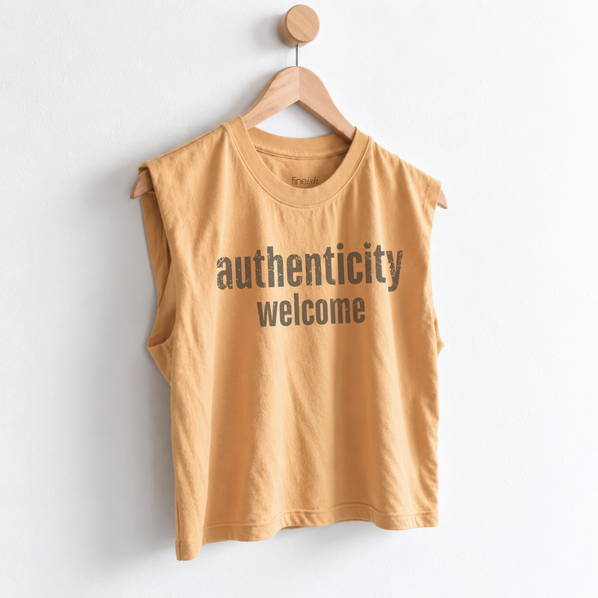 Women’s Authenticity Welcome muscle tank featuring a positive self-love message, heavyweight garment dyed cotton, mid length silhouette, relaxed boxy fit, and sleeveless design.