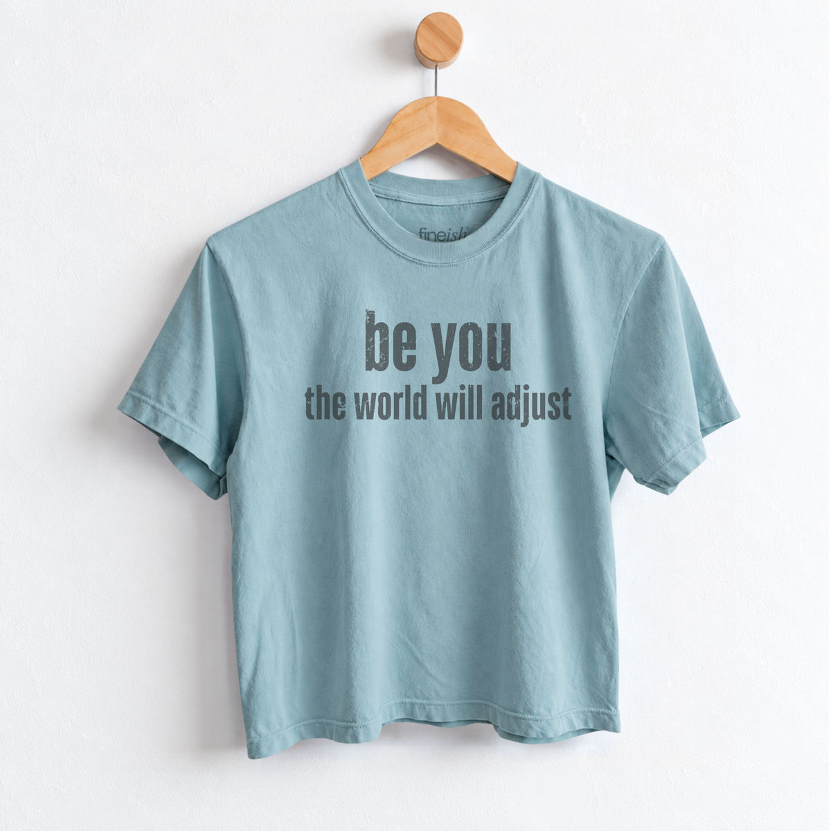 Women’s Be You The World Will Adjust graphic tee featuring an empowering self love message, with a relaxed mid length fit perfect for positive everyday style. Shop Fineish