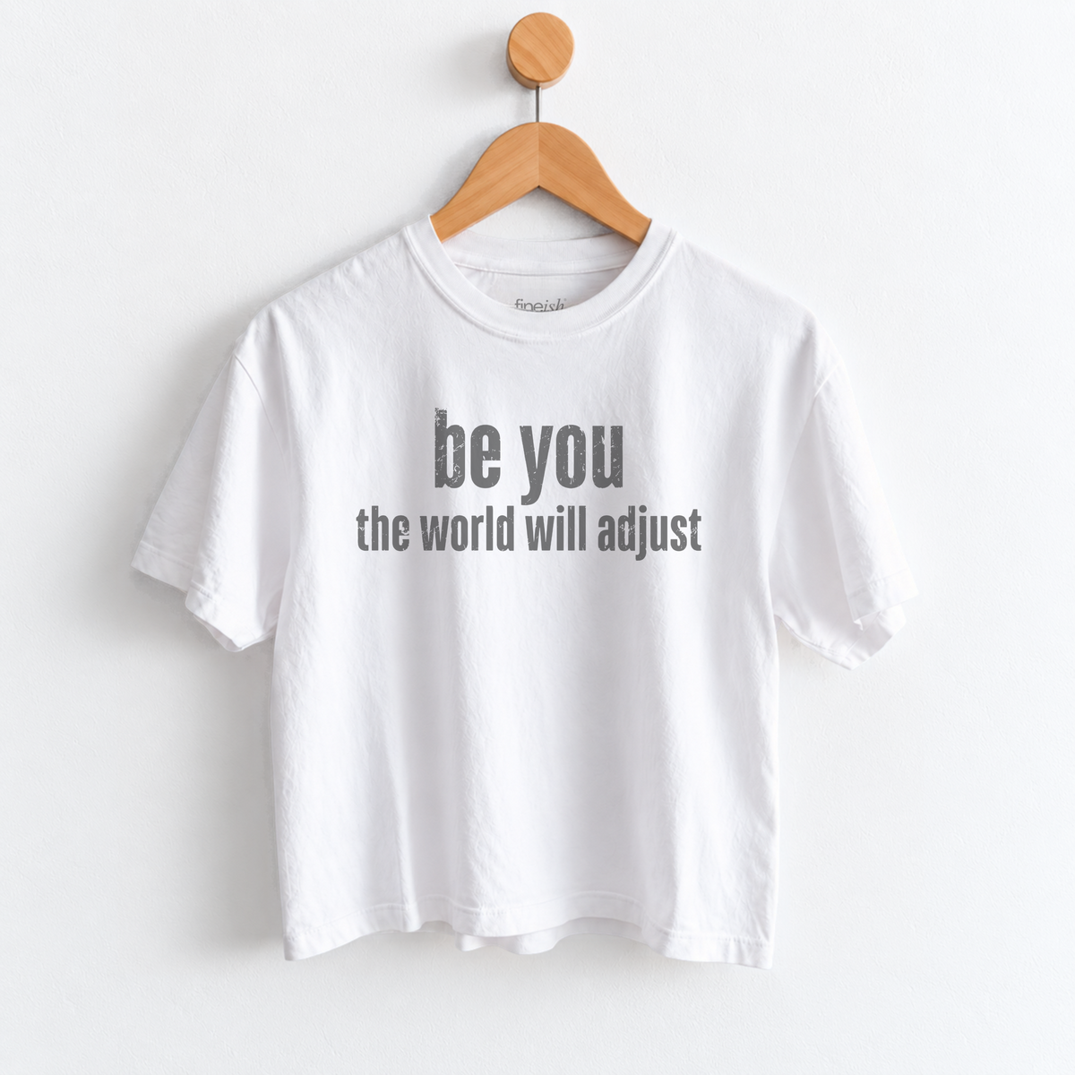 Women’s Be You The World Will Adjust graphic tee featuring an empowering self love message, with a relaxed mid length fit perfect for positive everyday style. Shop Fineish