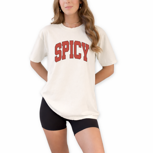 Unisex Spicy retro typography graphic t-shirt styled for bold confident streetwear outfit. Minimalist statement shirt in ivory and white for trendy summer and concert fashion looks.