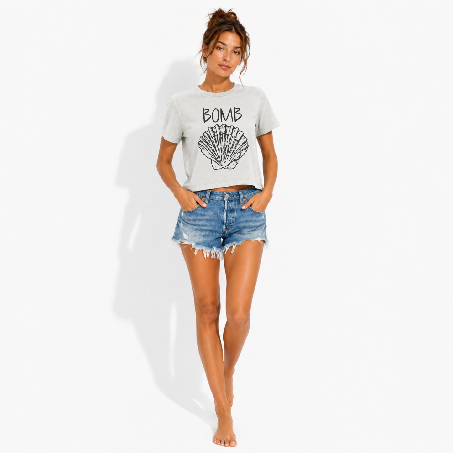 Close-up of the Bomb Shell seashell graphic printed on a women's washed garment-dyed t-shirt, highlighting the coastal artwork and vintage-style print.