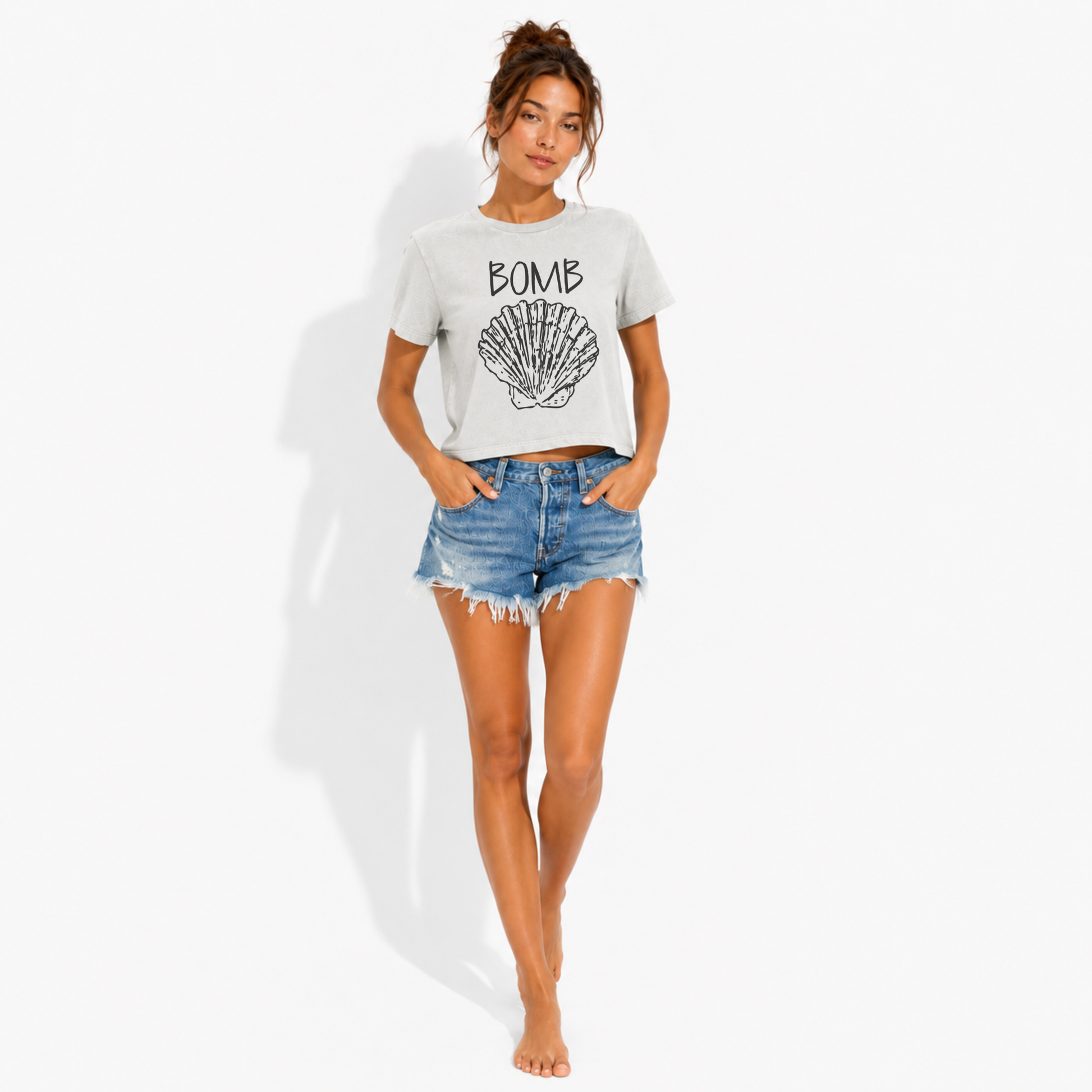 Close-up of the Bomb Shell seashell graphic printed on a women's washed garment-dyed t-shirt, highlighting the coastal artwork and vintage-style print.