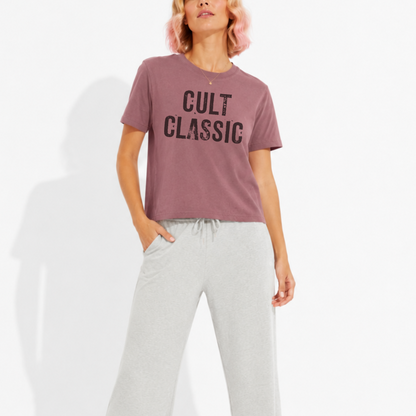 Woman wearing a washed garment-dyed t-shirt with a "Cult Classic" graphic, perfect for book lovers, bibliophiles, and fans of timeless literature.