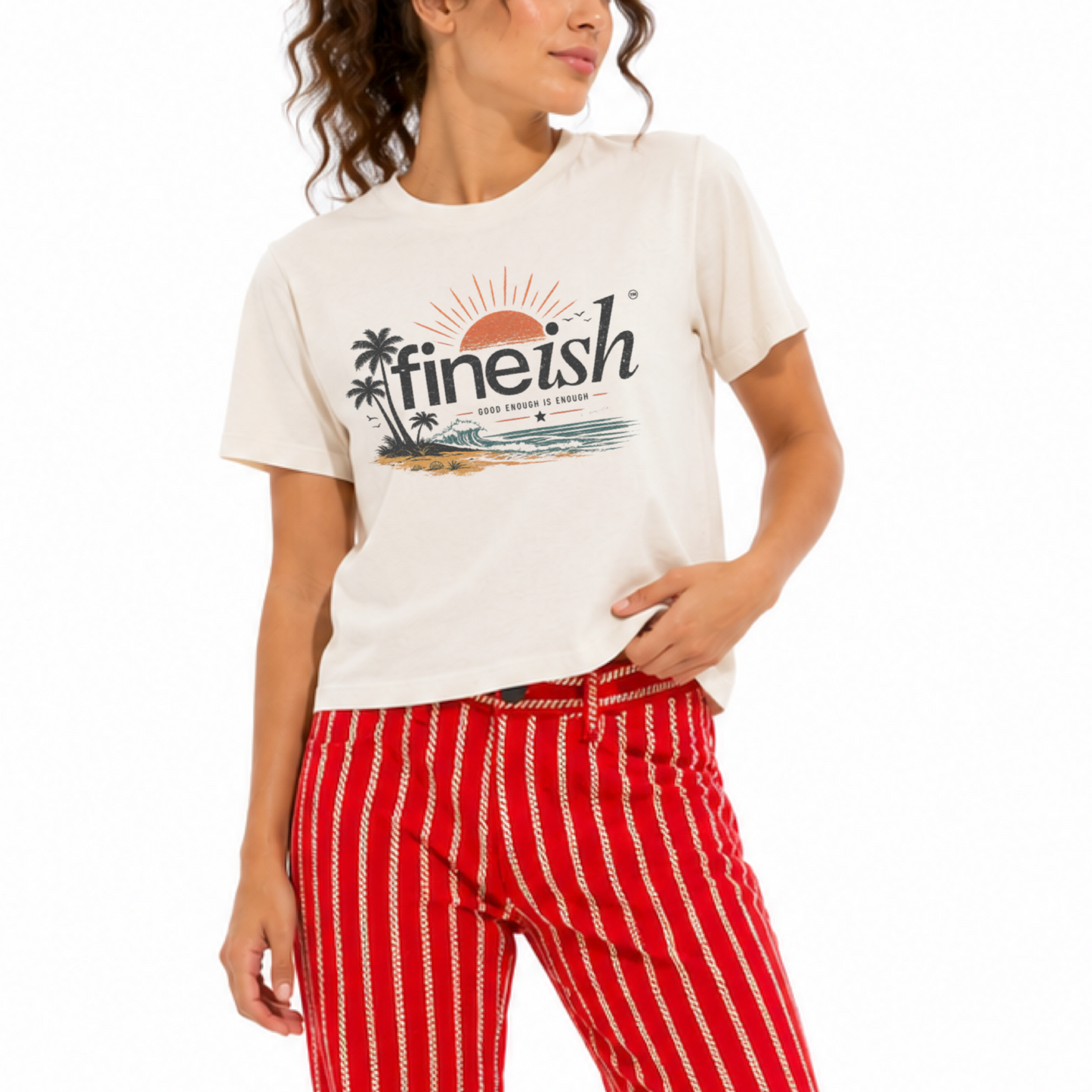 Woman wearing a vintage white FINEish garment-dyed T-shirt featuring a beach sunset graphic on the front.