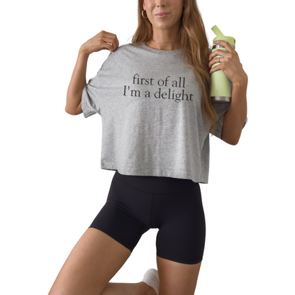 Women’s fitted crop tee with First of All I’m a Delight quote. Trendy graphic top for everyday wear.