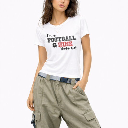 Woman wearing a lightweight graphic T-shirt that says "I'm a Football and Wine Kinda Girl," perfect for football season and game day.