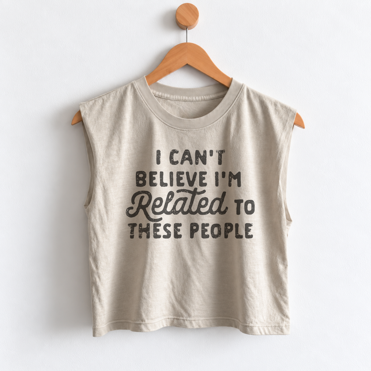Women’s funny Thanksgiving muscle tank featuring “I Can’t Believe I’m Related to These People” graphic, garment dyed heavyweight fabric, mid length boxy fit, and sleeveless design.