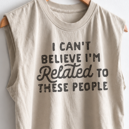 Women’s funny Thanksgiving muscle tank featuring “I Can’t Believe I’m Related to These People” graphic, garment dyed heavyweight fabric, mid length boxy fit, and sleeveless design.