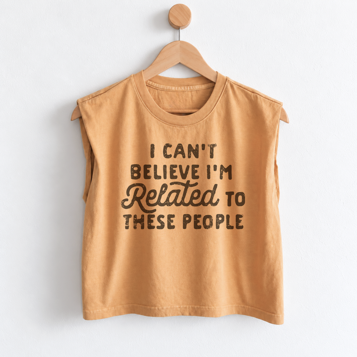 Women’s funny Thanksgiving muscle tank featuring “I Can’t Believe I’m Related to These People” graphic, garment dyed heavyweight fabric, mid length boxy fit, and sleeveless design.