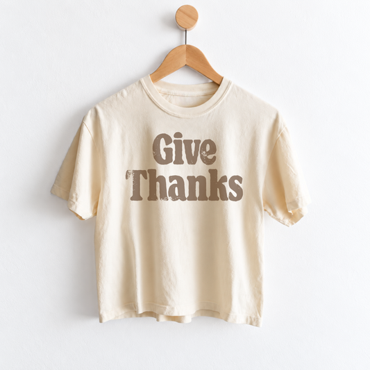 Women’s Give Thanks Thanksgiving graphic tee with garment dyed cotton fabric, mid length silhouette, relaxed fit, crew neckline, and festive fall holiday design.