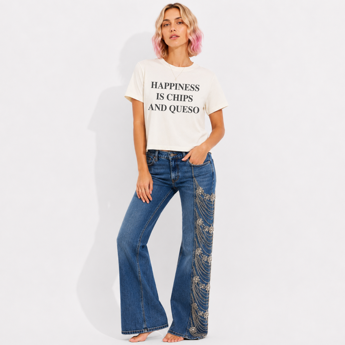 Woman wearing a mid-length garment-washed T-shirt featuring the phrase "Happiness Is Chips & Queso."