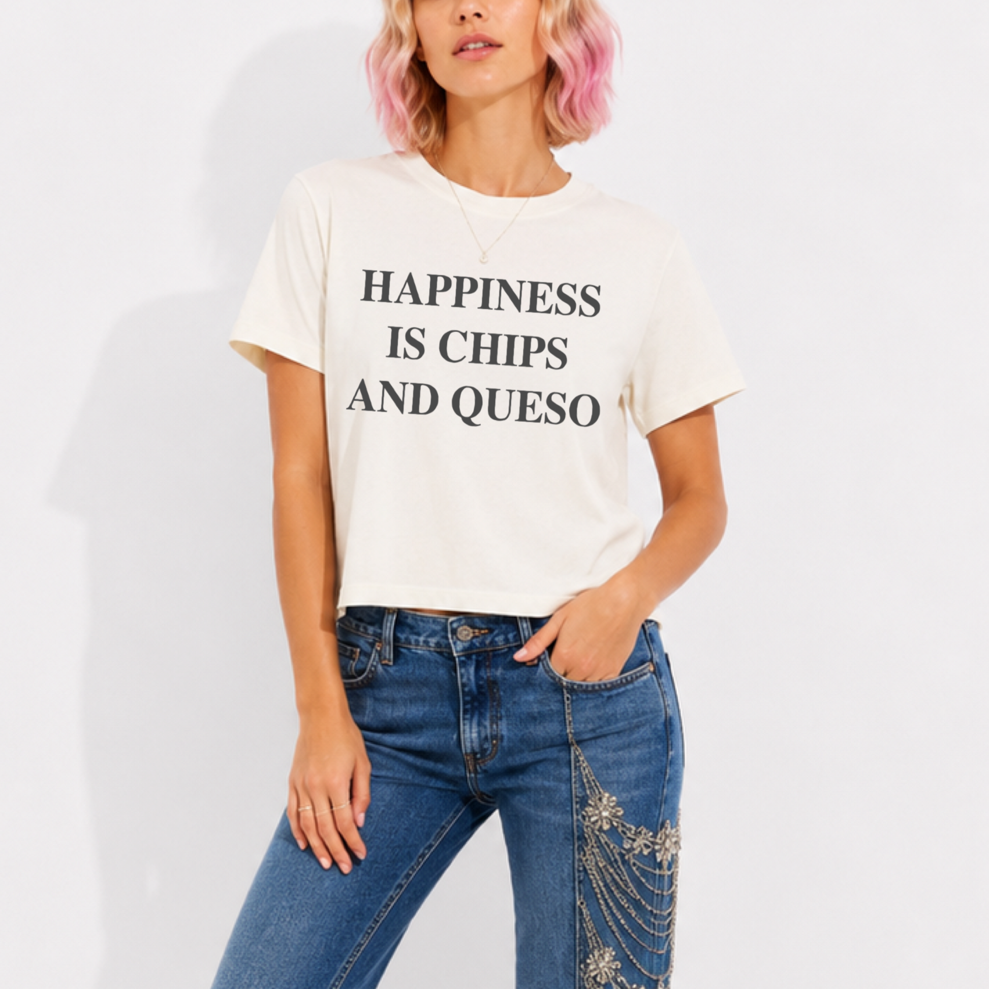 Woman wearing a mid-length garment-washed T-shirt featuring the phrase "Happiness Is Chips & Queso."