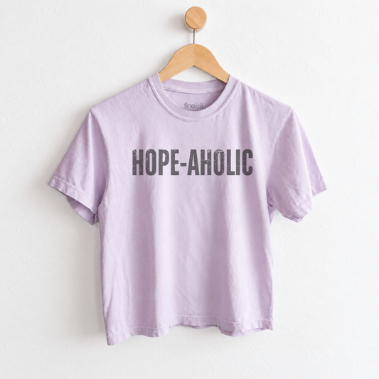 Women’s Hope-aholic graphic tee featuring a playful uplifting message about choosing hope and optimism, with a relaxed mid length fit for easy everyday style. Shop Fineish Tees