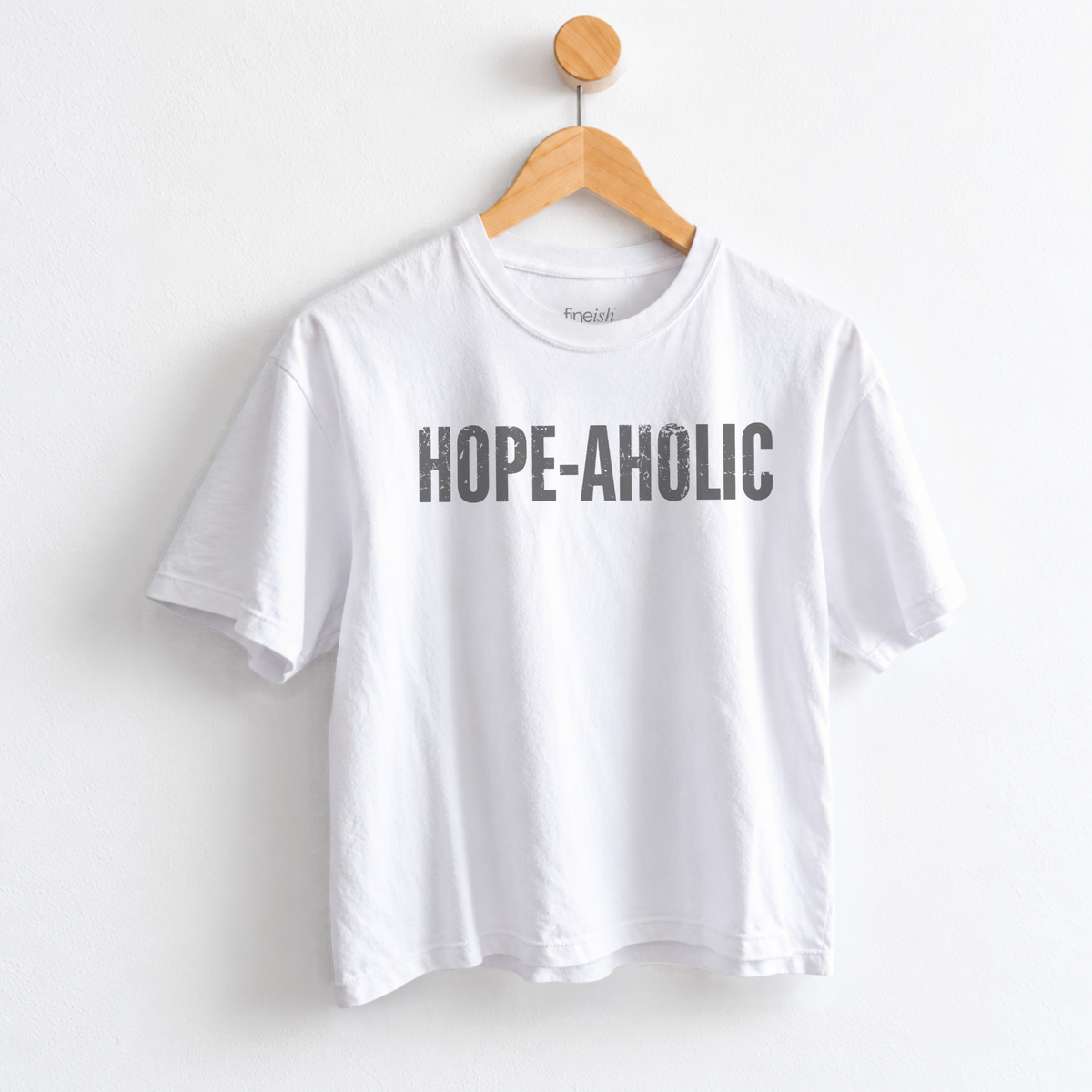 Women’s Hope-aholic graphic tee featuring a playful uplifting message about choosing hope and optimism, with a relaxed mid length fit for easy everyday style. Shop Fineish Tees