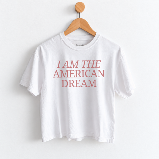 Women’s I Am the American Dream graphic tee featuring a patriotic American saying on a garment dyed mid length T-shirt, perfect for USA style and everyday Americana outfits. Shop Fineish