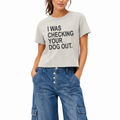 Woman wearing a vintage thyme heavyweight mid-length T-shirt featuring the phrase “I Was Checking Your Dog Out.”
