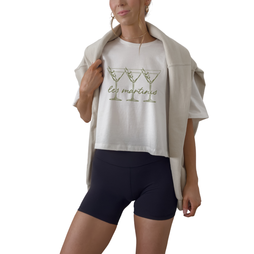 Women’s Les Martinis cropped graphic t-shirt styled for European summer and cocktail bar outfit. French inspired martini slogan crop top in off white mustard and athletic gray. Trendy girls trip outfit shirt perfect for bachelorette weekend and rooftop drinks
