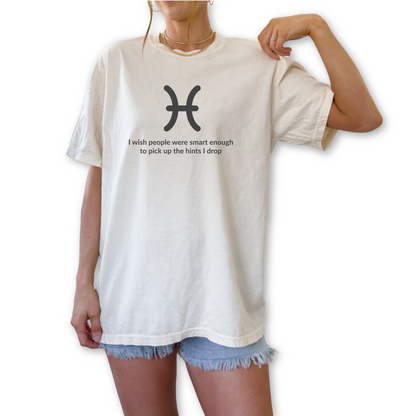 Funny Pisces zodiac horoscope shirt featuring “I Wish People Were Smart Enough to Pick Up the Hints I Drop.” Unique astrology gift for Pisces birthdays and water sign horoscope fans.
