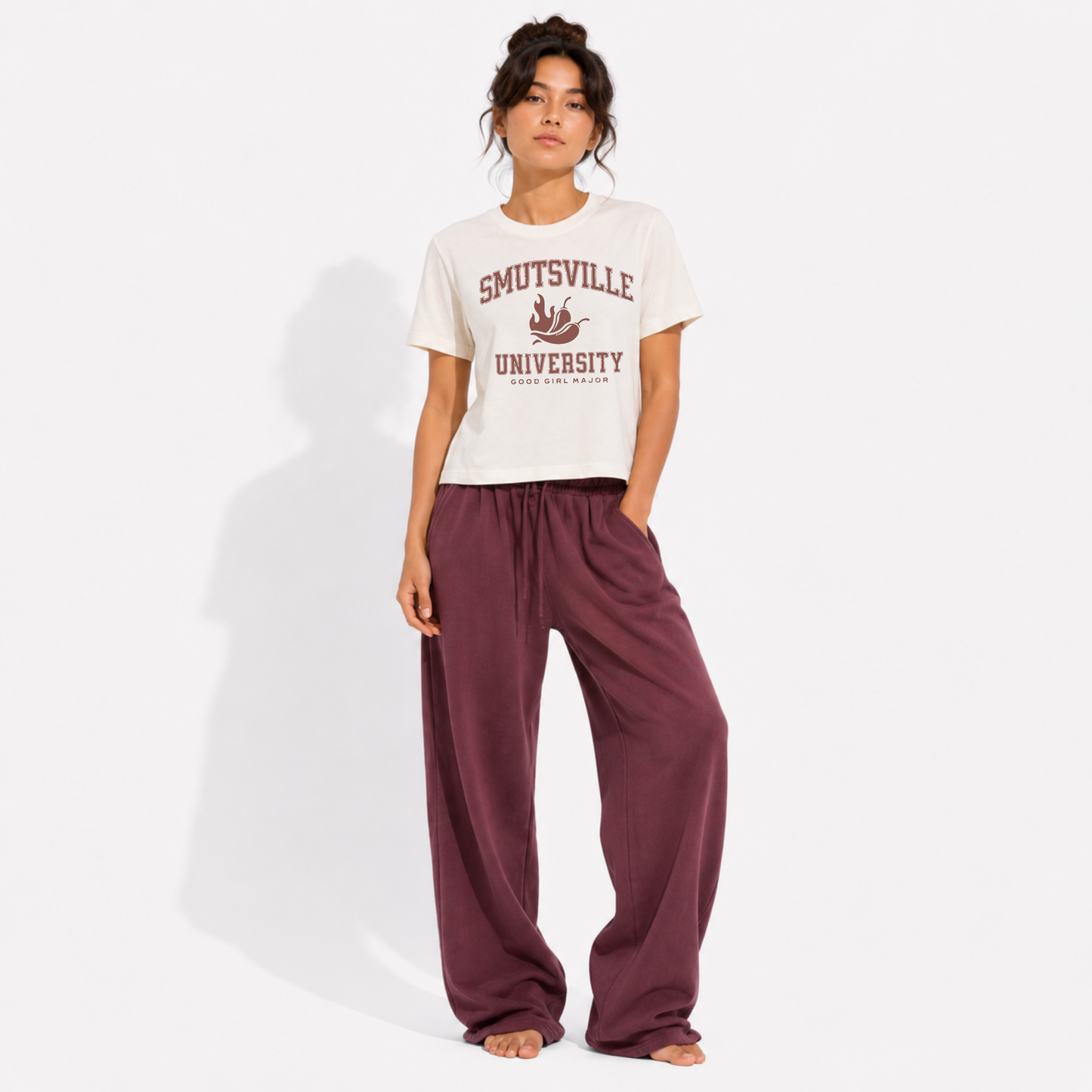 Woman wearing a washed garment-dyed t-shirt with a "Smutsville University – Good Girl Major" graphic, perfect for romance readers and lovers of spicy books.