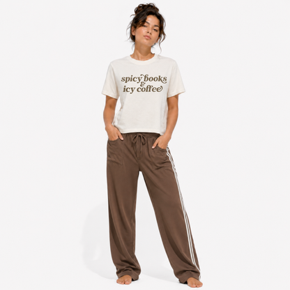 Close-up of the "Spicy Books & Icy Coffee" graphic printed on a women's washed garment-dyed t-shirt, highlighting the detailed typography and vintage-inspired print quality.
