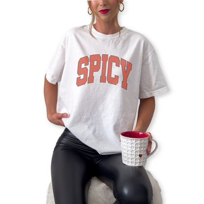 Unisex Spicy retro typography graphic t-shirt styled for bold confident streetwear outfit. Minimalist statement shirt in ivory and white for trendy summer and concert fashion looks.