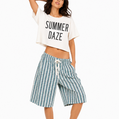 Woman wearing a heavyweight boxy crop tee featuring the phrase "Summer Daze" with a fun beach-inspired graphic, creating a relaxed coastal summer look.