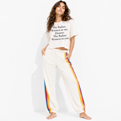 Woman wearing a boxy crop T-shirt featuring the phrase “The Badass Woman in Me Honors the Badass Woman in You.”