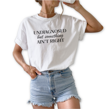Undiagnosed but Something Ain’t Right unisex graphic t-shirt featuring sarcastic humor statement design.